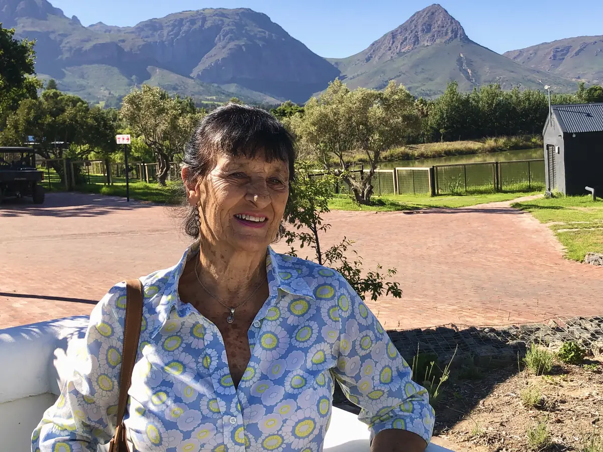 Anita, the soap maker behind Moondance, smiling in the sun with the Cape mountains behind her